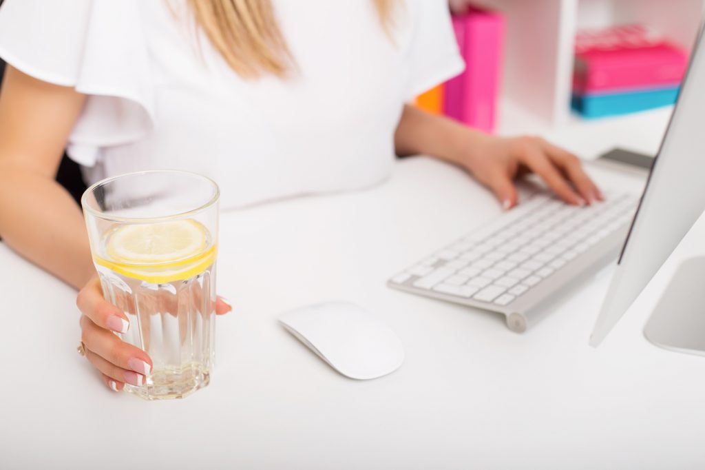 Woman having lemon water while working
